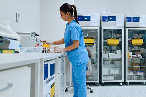 A technician handling blood samples in a diagnostic laboratory