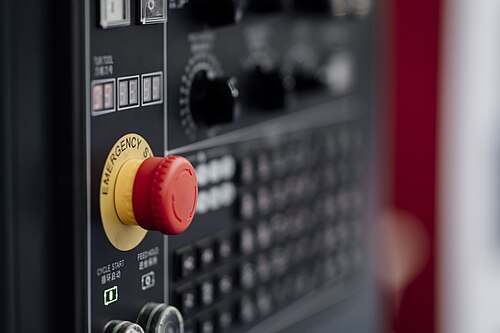 An emergency stop button on a machine control panel: a safety component